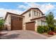 Two-story home featuring a three-car garage, desert landscaping, and a red tile roof at 17652 W Straight Arrow Ln, Surprise, AZ 85387