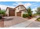 Two-story home featuring a three-car garage, desert landscaping, and a red tile roof at 17652 W Straight Arrow Ln, Surprise, AZ 85387