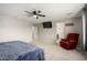 Spacious primary bedroom with TV, ceiling fan, and view into the en suite bathroom at 17652 W Straight Arrow Ln, Surprise, AZ 85387