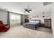 Large primary bedroom with neutral carpet, ceiling fan, and window with views at 17652 W Straight Arrow Ln, Surprise, AZ 85387