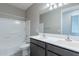Bathroom featuring double sink vanity, large mirror, tiled floors, and a shower-tub combo at 18766 W Montebello Ave, Litchfield Park, AZ 85340