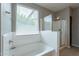 Bathroom featuring a soaking tub and a glass shower with light wooden look flooring at 18766 W Montebello Ave, Litchfield Park, AZ 85340
