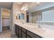 Bathroom with double sinks, a large mirror, and access to a walk-in closet and shower at 18766 W Montebello Ave, Litchfield Park, AZ 85340