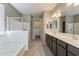 Bright bathroom featuring double sinks, a glass shower, and a soaking tub at 18766 W Montebello Ave, Litchfield Park, AZ 85340