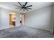 Neutral bedroom featuring gray carpet, ceiling fan and ensuite bathroom and closet at 18766 W Montebello Ave, Litchfield Park, AZ 85340