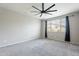 Bedroom with gray carpet, ceiling fan, and large windows bringing in plenty of natural light at 18766 W Montebello Ave, Litchfield Park, AZ 85340