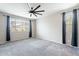 Bright bedroom with gray carpet, a ceiling fan, and natural light from windows at 18766 W Montebello Ave, Litchfield Park, AZ 85340