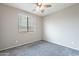 Bedroom with gray carpet, a ceiling fan, and a window with blinds for natural light at 18766 W Montebello Ave, Litchfield Park, AZ 85340