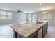 Kitchen island featuring granite countertop, stainless steel sink, and open access to the living area at 18766 W Montebello Ave, Litchfield Park, AZ 85340