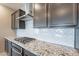 Elegant kitchen with granite countertops, stainless steel vent hood, and white backsplash at 18766 W Montebello Ave, Litchfield Park, AZ 85340