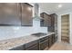 Kitchen featuring granite countertops, white backsplash, stainless steel vent hood, and dark cabinets at 18766 W Montebello Ave, Litchfield Park, AZ 85340