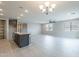 Open-concept living room with a large island, modern chandelier, and wood-look tile flooring at 18766 W Montebello Ave, Litchfield Park, AZ 85340