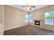 A cozy bedroom featuring a ceiling fan, a fireplace, and three windows allowing natural light with neutral walls at 1909 N 106Th Ave, Avondale, AZ 85392