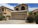 Charming two-story home featuring a two-car garage and a well-maintained desert landscape under a sunny sky at 1909 N 106Th Ave, Avondale, AZ 85392