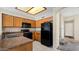 Functional kitchen featuring wood cabinets, black appliances, and tiled flooring, offering a practical cooking space at 1909 N 106Th Ave, Avondale, AZ 85392