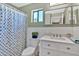 Charming bathroom with wainscoting, updated vanity, and stylish shower curtain at 2418 W White Feather Ln, Phoenix, AZ 85085