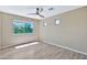 Bedroom featuring wood-look floors, a ceiling fan, and large windows at 2418 W White Feather Ln, Phoenix, AZ 85085