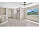 Bright bedroom featuring wood-look floors, a ceiling fan, and a large window at 2418 W White Feather Ln, Phoenix, AZ 85085