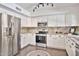 Well-lit kitchen with stainless steel appliances, granite countertops, and decorative tile flooring at 2418 W White Feather Ln, Phoenix, AZ 85085