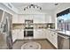 Bright kitchen featuring stainless steel appliances, white cabinetry, and granite countertops at 2418 W White Feather Ln, Phoenix, AZ 85085