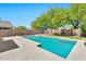 Relax by the refreshing pool, complete with a pergola and surrounded by lush landscaping and privacy walls at 2418 W White Feather Ln, Phoenix, AZ 85085