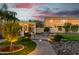 Inviting backyard featuring a pergola, a fire pit, an outdoor kitchen, lush landscaping, and cafe string lights at 26065 N 74Th Dr, Peoria, AZ 85383