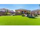 Expansive backyard with artificial turf, a pergola, and comfortable seating for outdoor entertainment at 26065 N 74Th Dr, Peoria, AZ 85383