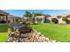 Expansive backyard featuring lush green grass, a rock garden with bridge, and a white pergola with seating at 26065 N 74Th Dr, Peoria, AZ 85383