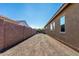 Long, gravel backyard behind a tan home and block wall offers easy maintenance at 26065 N 74Th Dr, Peoria, AZ 85383