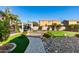 Well-manicured backyard with a stone pathway, outdoor seating area, and lush artificial turf at 26065 N 74Th Dr, Peoria, AZ 85383