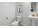 Small bathroom featuring a pedestal sink, toilet, and light beige tile flooring at 26065 N 74Th Dr, Peoria, AZ 85383