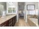 A primary bathroom features granite counters, tile floor, bath tub and glass enclosed shower at 26065 N 74Th Dr, Peoria, AZ 85383