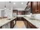 Well-lit kitchen with stainless steel appliances, granite counters, and dark wood cabinetry at 26065 N 74Th Dr, Peoria, AZ 85383