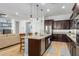 Bright kitchen with granite countertops, stainless steel appliances, an island with seating and views to the living room at 26065 N 74Th Dr, Peoria, AZ 85383
