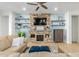 A cozy living room with a stone fireplace, floating shelves, and comfortable seating at 26065 N 74Th Dr, Peoria, AZ 85383