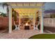 Backyard pergola with an outdoor fireplace, comfortable seating, and cafe string lights at 26065 N 74Th Dr, Peoria, AZ 85383