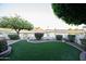 Relaxing backyard featuring artificial turf, a quaint fence, and tranquil pond vistas at 2635 N 62Nd St, Mesa, AZ 85215