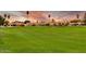 Expansive view of a well-maintained golf course with green fairways and palm trees under a vibrant sunset at 2635 N 62Nd St, Mesa, AZ 85215