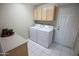 Functional laundry room with a washer, dryer, and overhead storage cabinets at 2635 N 62Nd St, Mesa, AZ 85215