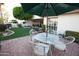Charming brick patio featuring an umbrella-covered table and chairs, surrounded by well-manicured landscaping at 2635 N 62Nd St, Mesa, AZ 85215