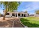 Back exterior view highlighting a large, well-maintained backyard with a covered patio, lush lawn, and convenient access pathways at 28061 N Holly Rd, San Tan Valley, AZ 85143