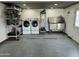 Organized garage with laundry area, stainless steel dog wash station, and ample storage at 28061 N Holly Rd, San Tan Valley, AZ 85143