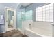 Bathroom features a bathtub, shower, and glass block window, creating a spa-like atmosphere at 3025 W Sentinel Rock Rd, Phoenix, AZ 85086