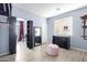 Well-lit dressing room with a pink velvet ottoman, modern shelving, and light wood flooring at 3025 W Sentinel Rock Rd, Phoenix, AZ 85086