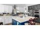 Gourmet kitchen featuring white cabinets, stainless steel appliances, and a blue island at 3025 W Sentinel Rock Rd, Phoenix, AZ 85086