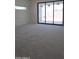 A spacious, unfinished bedroom with a large window and black frame sliding glass doors at 3374 E Aquarius Ct, Chandler, AZ 85249