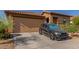 View of home exterior showcasing garage and a black car parked on driveway at 4050 W Coles Rd, Laveen, AZ 85339
