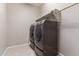 Efficient laundry room featuring modern washer and dryer units with overhead shelving at 4050 W Coles Rd, Laveen, AZ 85339