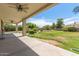 Expansive backyard featuring a covered patio with ceiling fans, a lush lawn, and mature landscaping at 4490 S Rio Dr, Chandler, AZ 85249