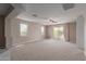 Large bonus room with neutral carpet, large windows, and a ceiling fan at 4490 S Rio Dr, Chandler, AZ 85249